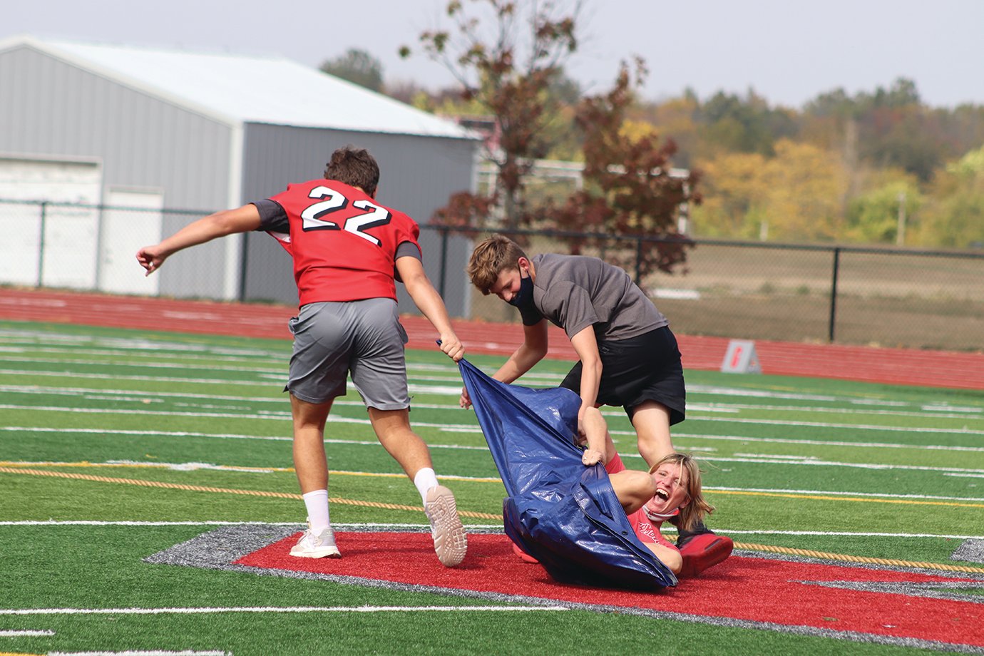 Teacher Cindy Bannon redefines the term "kicking and screaming" as she is dragged across midfield Friday.